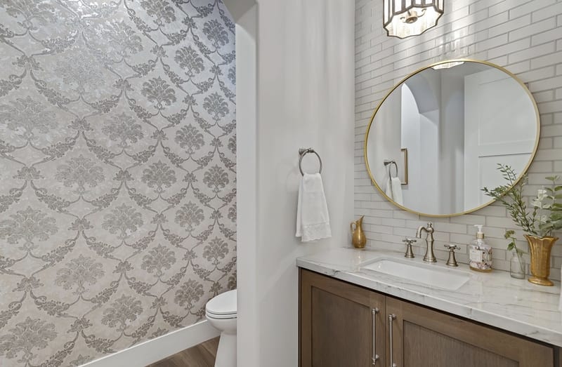 Powder room with wallpaper and brass accents