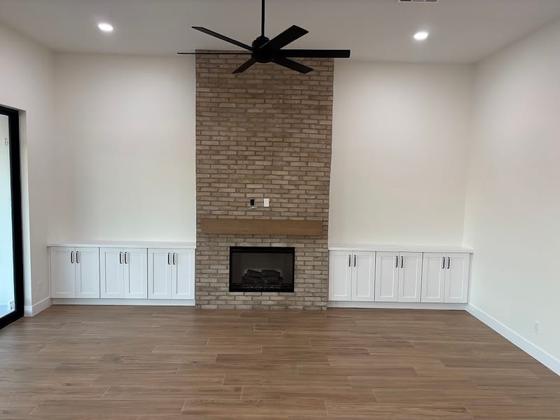 Living room with brick fireplace and built-ins
